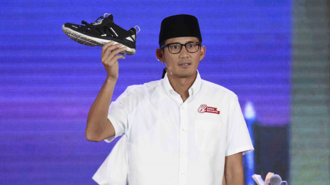 Calon Wakil Gubernur DKI Jakarta Sandiaga Uno menujukkan sepatunya saat menjawab pertanyaan dalam debat ketiga Pilkada DKI Jakarta di Jakarta, Jumat, 10 Februari 2017.