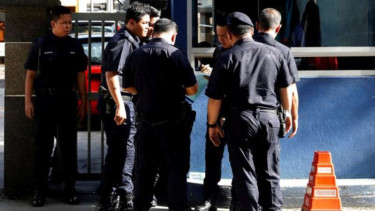 Polisi Malaysia berjaga di depan rumah sakit tempat jasad Jong-nam disemayamkan.