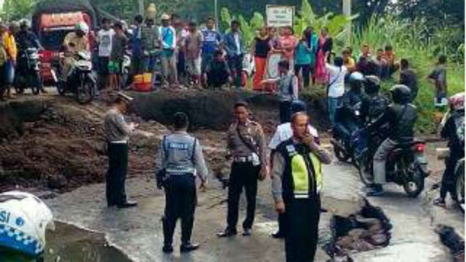 Jalan amblas di di Desa Bugel, Kecamatan Tomo, Kabupaten Sumedang, Jawa Barat.