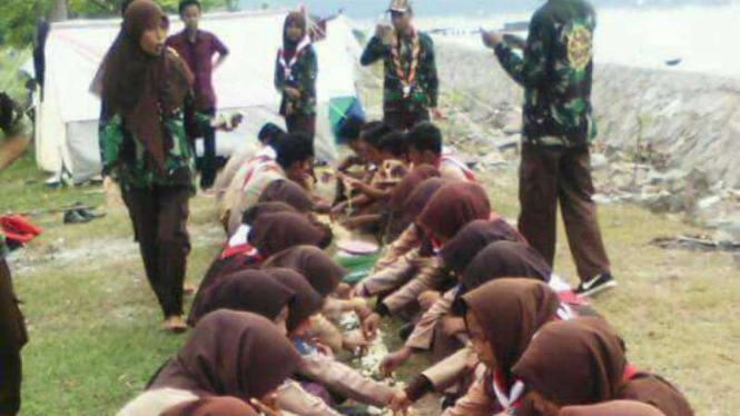 Foto yang menampilkan anggota Pramuka di wilayah Tangerang Banten sedang makan bersama di atas rumput. Foto ini beredar di jejaring sosial dan menuai kecaman.