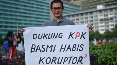 Aktor senior Pong Harjatmo melakukan aksi dengan membawa poster ketika pelaksanaan Hari Bebas Kendaraan Bermotor di Kawasan Bundaran HI Jakarta.