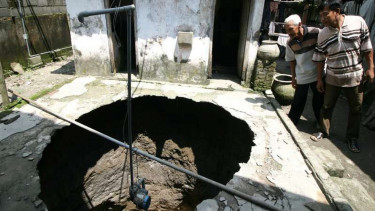 Warga mengamati sumur yang baru saja ambles di Dusun Nanas, Desa Manggis, Kecamatan Puncu, Kediri, Jawa Timur, Kamis (27/4/2017).