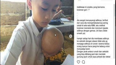 Boisman Gori, siswa kelas 5 SD asal Pulau Nias yang bersekolah sembari menggendong adik lelakinya.