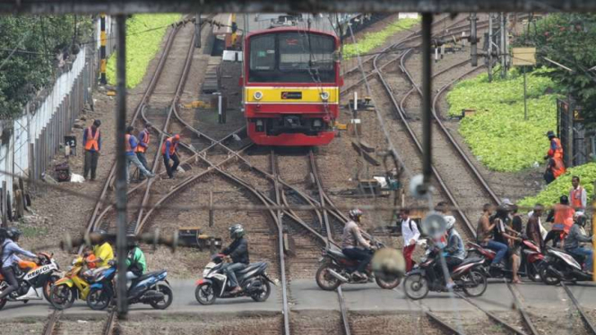 Kereta KRL Commuter Line bersiap lewati perlintasan sebidang di Jatinegara. (ilustrasi)