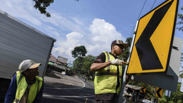 Pekerja memasang rambu jalan di Kersamanah, Garut, Jawa Barat, Selasa (30/5/2017). Penambahan rambu di jalur selatan Jawa Barat ini untuk kesiapan arus mudik Lebaran 2017. 