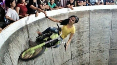 Karmila beratraksi di atas motornya.