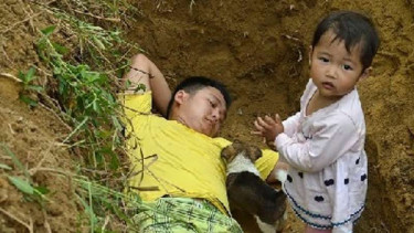 Zhang Liyong dan Xin Lei bermain di makam yang telah dibuat.