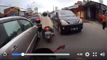 Ibu pengendara motor saat selap-selip di kemacetan.