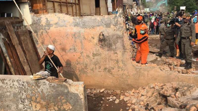 Haji Naim (berpeci putih) sedang robohkan rumahnya.