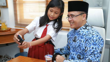Bupati Banyuwangi, Abdullah Azwar Anas, bersama seorang siswi yang kini diterima di SMPN 3 Genteng, Senin (17/7/2017).