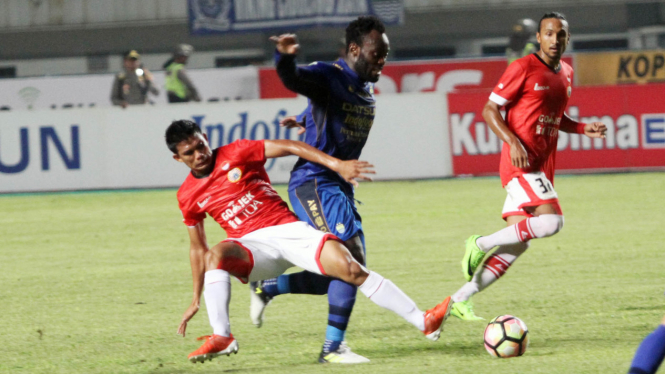 Gelandang Persija Jakarta, Sandi Darma Sute berhadapan dengan Michael Essien.