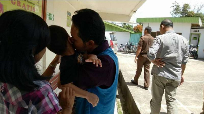  Fidelis Arie Sudewarto mencium anak bungsunya di PN Sanggau Kalimantan Barat. Pria ini divonis 8 bulan penjara karena menanam ganja untuk obat istrinya.