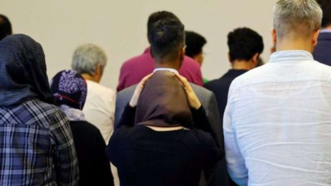 Pria dan wanita salat bersama dalam satu saf.