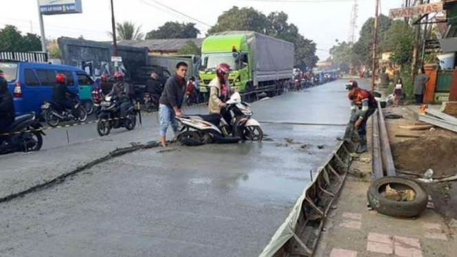 Aksi emak-emak lewati cor beton basah.