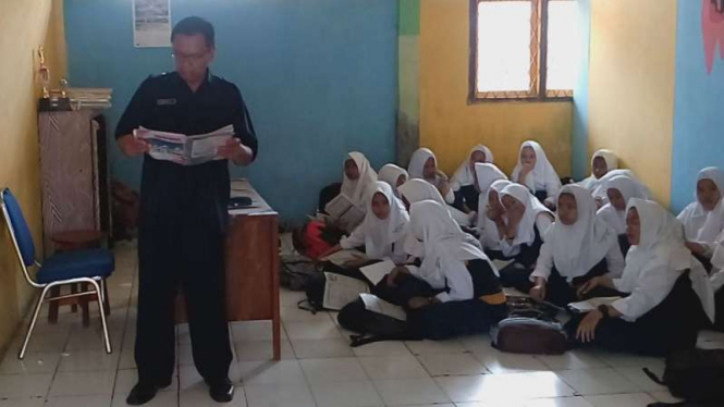 Para siswa di Madrasah Tsanawiyah Negeri Kota Depok, Jawa Barat, belajar beralaskan lantai alias lesehan karena tak ada bangku dan meja untuk mereka di ruang-ruang kelasnya.