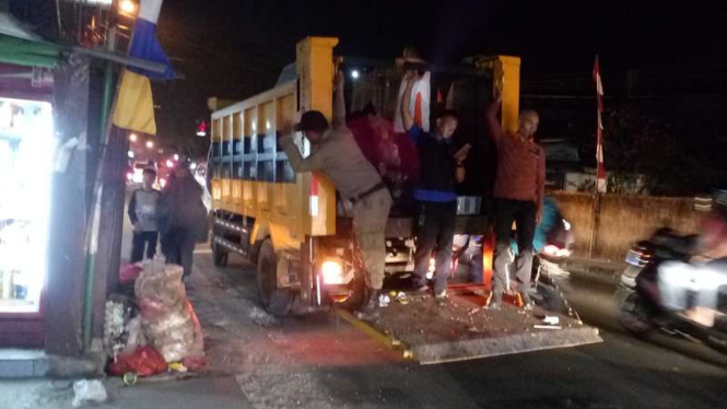Sejumlah petugas Satpol PP Kota Depok memunguti sampah yang berceceran di jalanan Kota Depok, sejak para sopir angkut sampah menggelar mogok massal, Selasa (22/8/2017)