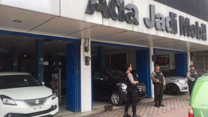 Polisi bersenjata berjaga-jaga saat penyidik KPK menggeledah showroom mobil 