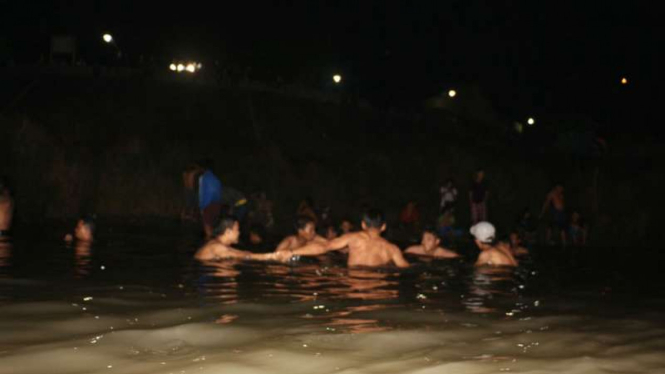 Sejumlah warga berendam atau kungkum sebagai tradisi menyambut Tahun Baru Islam setiap 1 Muharam atau 1 Suro di Tugu Suharto, Semarang, Jawa Tengah.