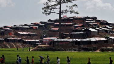 Warga etnis Rohingya meninggalkan desa mereka di Rakhine, Myanmar.