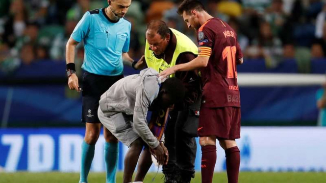 Penonton nekat masuk ke dalam lapangan demi mencium kaki kiri Lionel Messi