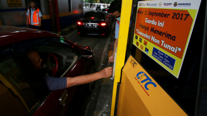 Pengendara melakukan transaksi pembayaran tol non tunai di gerbang tol Pejompongan, Jakarta, Selasa (12/9).