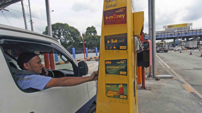 Seorang pengemudi mobil pengguna jalan tol bertransaksi menggunakan kartu elektronik non tunai ketika akan keluar dari tol Belmera Amplas Medan, Sumatera Utara