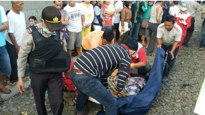 Kepolisian bersama warga mengevakuasi jasad dua petugas penjaga palang kereta di Stasiun Tanah Tinggi Tangerang yang tewas terseret kereta, Kamis (12/10/2017)