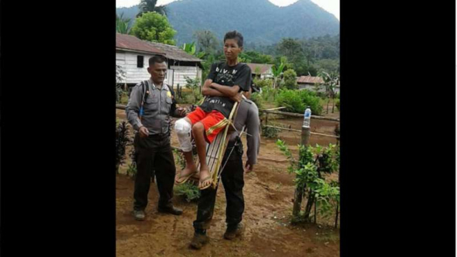  Kapolsek Bunta Iptu Candra saat menggendong warganya yang sakit untuk dibawa ke Puskesmas, Senin (16/10/2017)