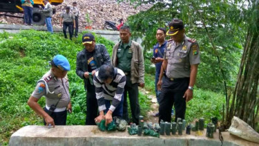 Polisi memeriksa barang bukti penemuan karung berisi granat dan amunisi aktif di Kota Depok, Jawa Barat, pada Kamis, 19 Oktober 2017.