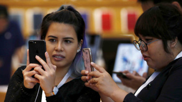 Sejumlah wanita mencoba gadget baru iPhone 8 Plus di Singapura