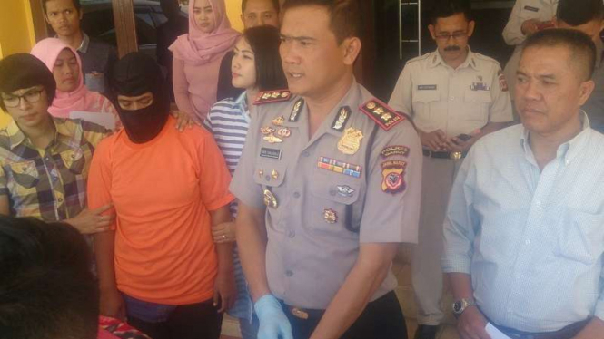 Cucu Cahyati (bertopeng) saat gelar perkara di Polres Garut.