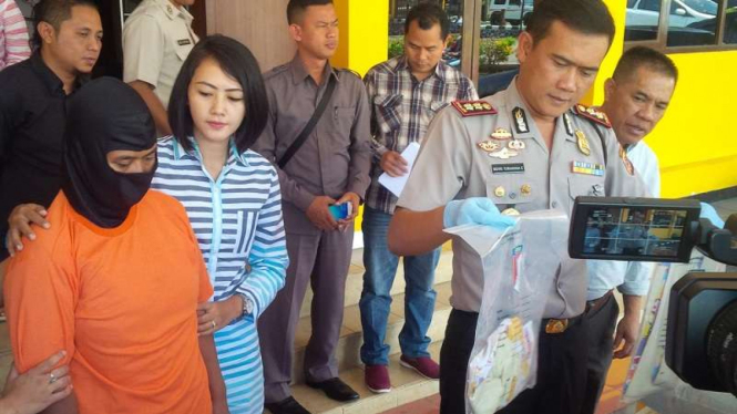 Cucu Cahyati (bertopeng) saat gelar perkara di Polres Garut. 