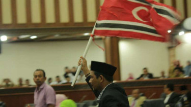 Anggota Dewan Aceh mengibarkan bendera bulan bintang dalam rapat paripurna di gedung DPR Aceh pada Selasa, 31 Oktober 2017.