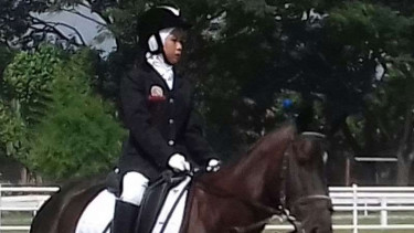 Seorang atlet olahraga equestrian dan kudanya.