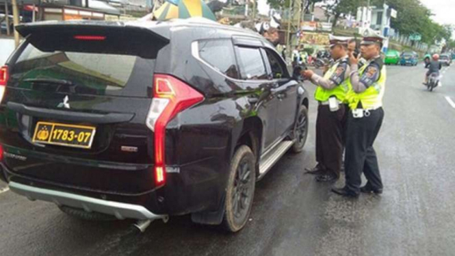 Mobil berpelat nomor dinas kepolisian.