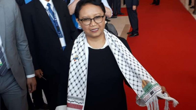 Menlu Retno memamerkan syal buatan perempuan Palestina.