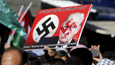 Foto Donald Trump yang dicoret dan dibakar oleh para peserta aksi unjuk rasa