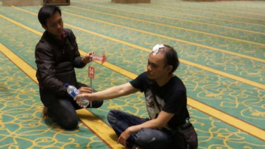 Suharmin saat memperagakan cara siram air kencing di Masjid Kubah Emas.