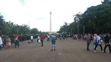 Warga bersantai di kawasan Monas, Senin 1 Januari 2018.