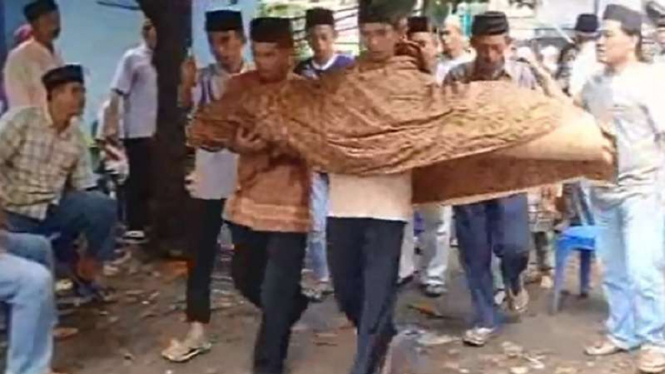 Jenazah Rizki digendong ayahnya ke pemakaman.