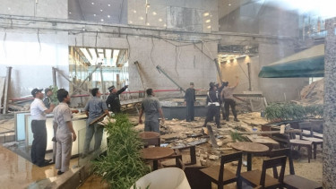Pekerja mengamati kerusakan yang terjadi akibat ambruknya selasar Tower 2 BEI.