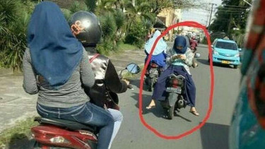 Naik motor hadap belakang.