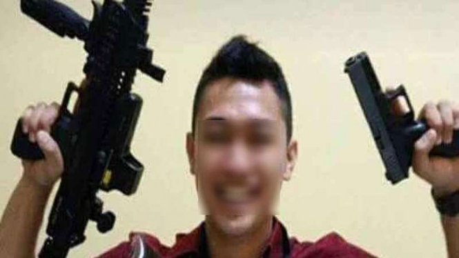 Briptu AR saat memegang dua senjata sekaligus.