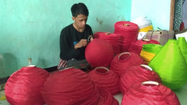 Salah satu pegawai lampion Achmad mengerjakan pesanan.