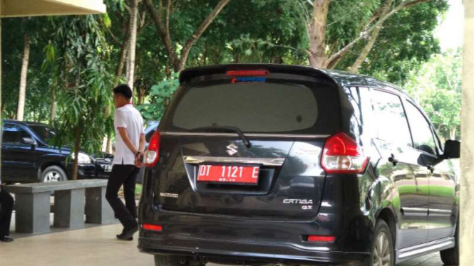 Mobil pelat merah milik Pemkot Kendari di depan ruang pemeriksaan Polda Sultra