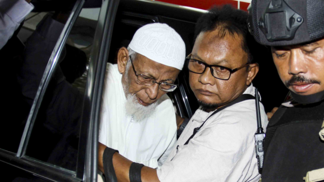 Terpidana kasus terorisme, Abu Bakar Ba'asyir (kiri) dengan pengawalan petugas.