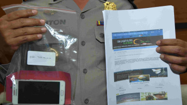 Barang bukti berupa telepon pintar dan 