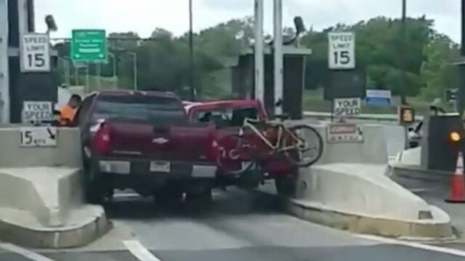 Dua mobil rebutan masuk gerbang tol.