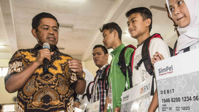 Menteri Sosial, Idrus Marham (kiri) memberikan bantuan secara simbolis program keluarga harapan (PKH)