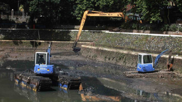 Pengerukan lumpur yang mengendap menggunakan beko di waduk komplek Kantor Wali Kota Jakarta Selatan